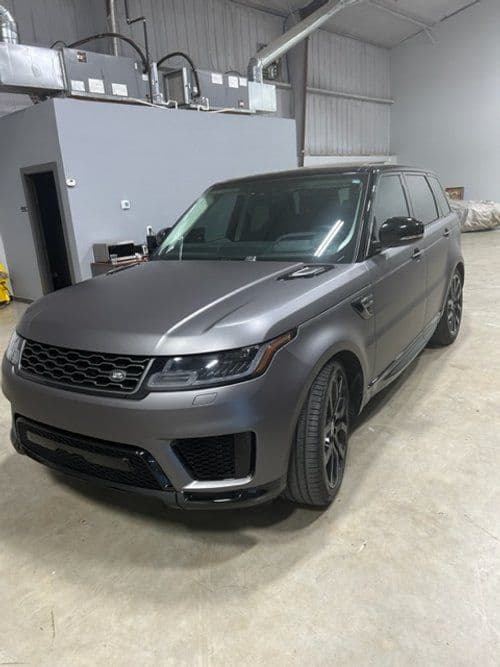 A gray range rover sport is parked in a garage