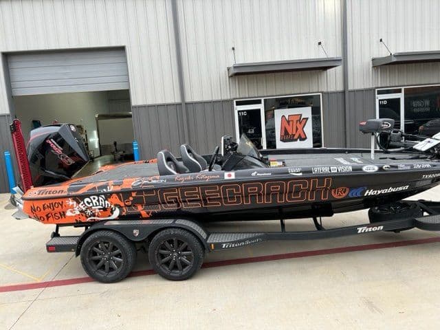A boat is parked on a trailer in front of a building