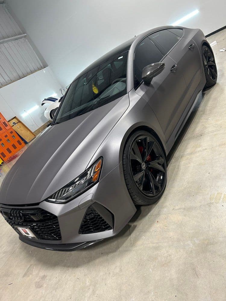 A gray audi rs7 is parked in a garage
