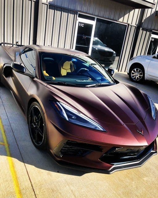 A red sports car is parked in front of a building