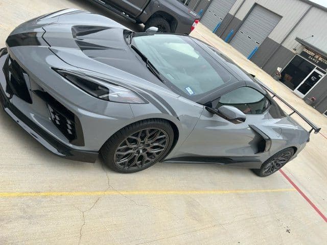 A gray sports car is parked in a parking lot