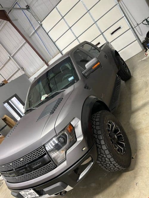 A ford raptor truck is parked in a garage