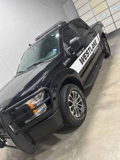 A black truck with the word westlake on the side is parked in a garage