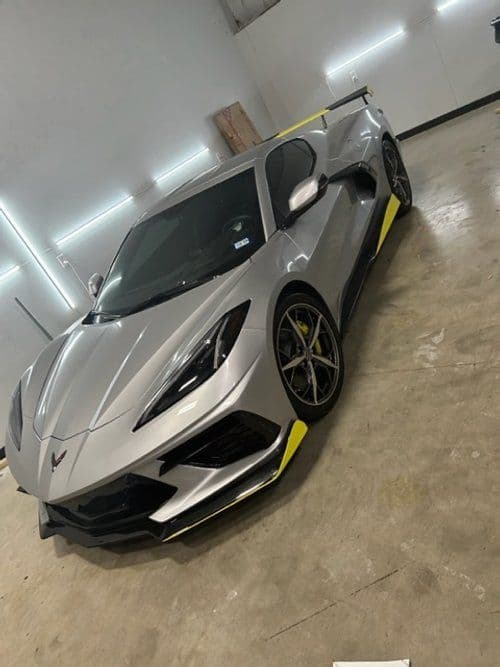 A silver sports car is parked in a garage