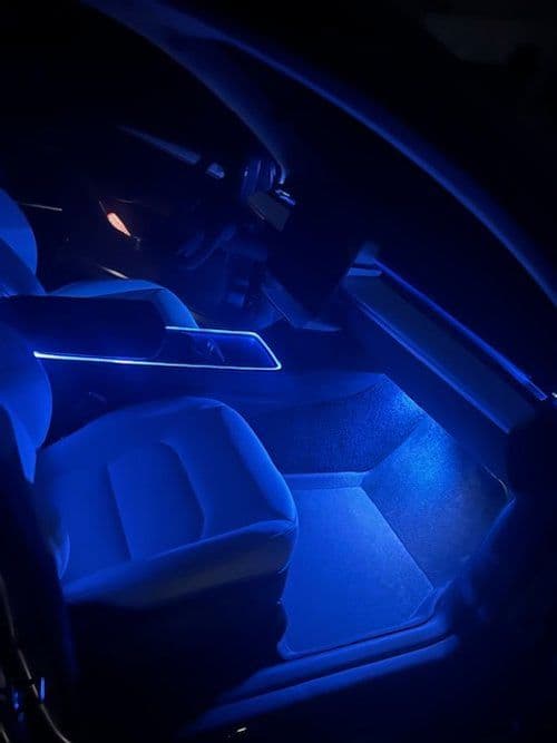 The interior of a car is lit up with blue lights