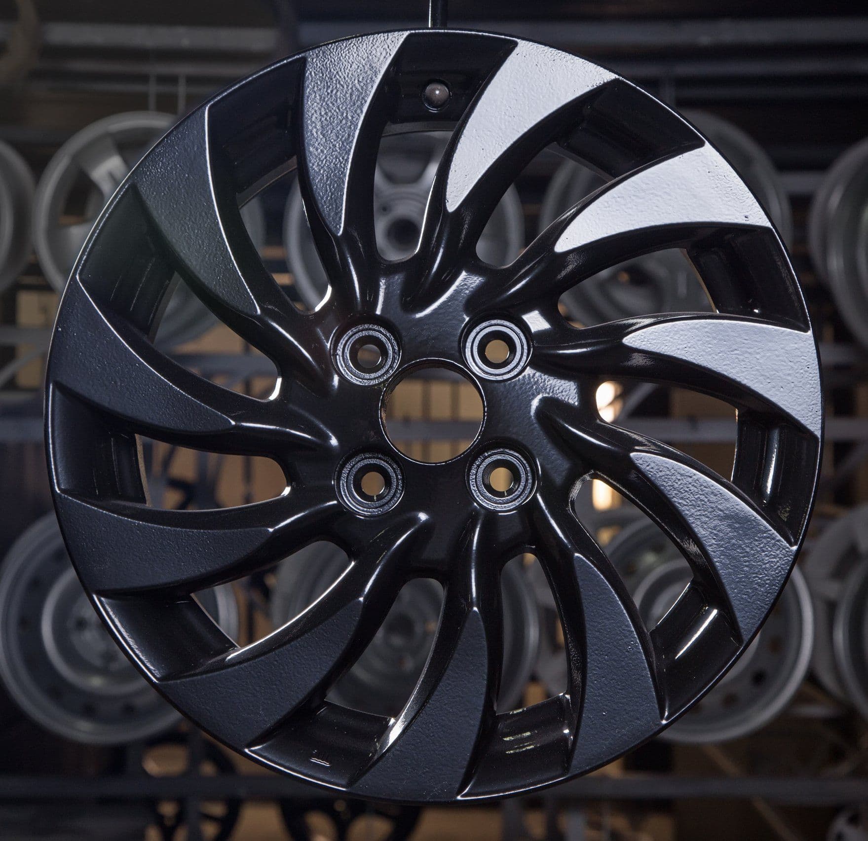 A black and white wheel is hanging from a metal rack